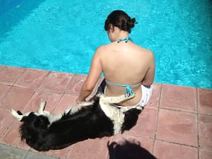Laura sat by the swimming pool with Poppy